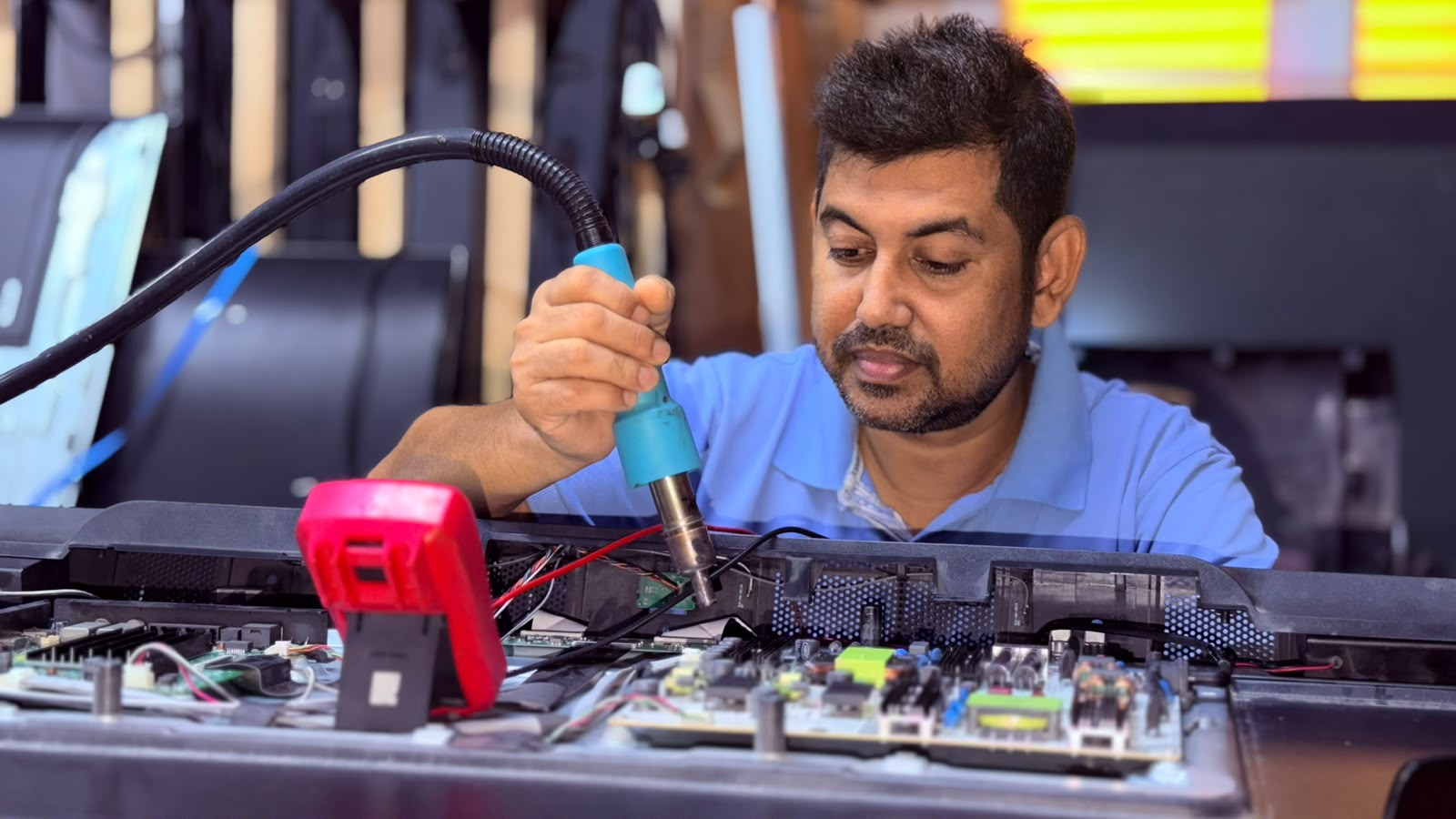 TV repair technician carefully diagnosing electronic components
